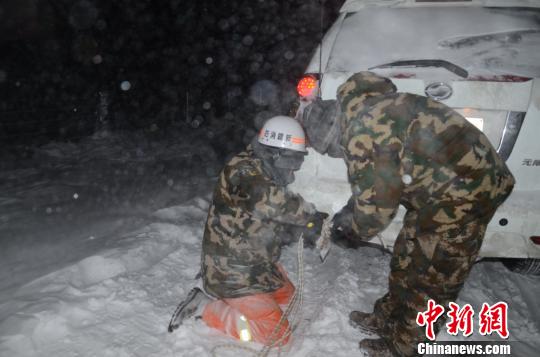 圖為消防救援人員給被困車輛安裝救援繩?！±罱?攝